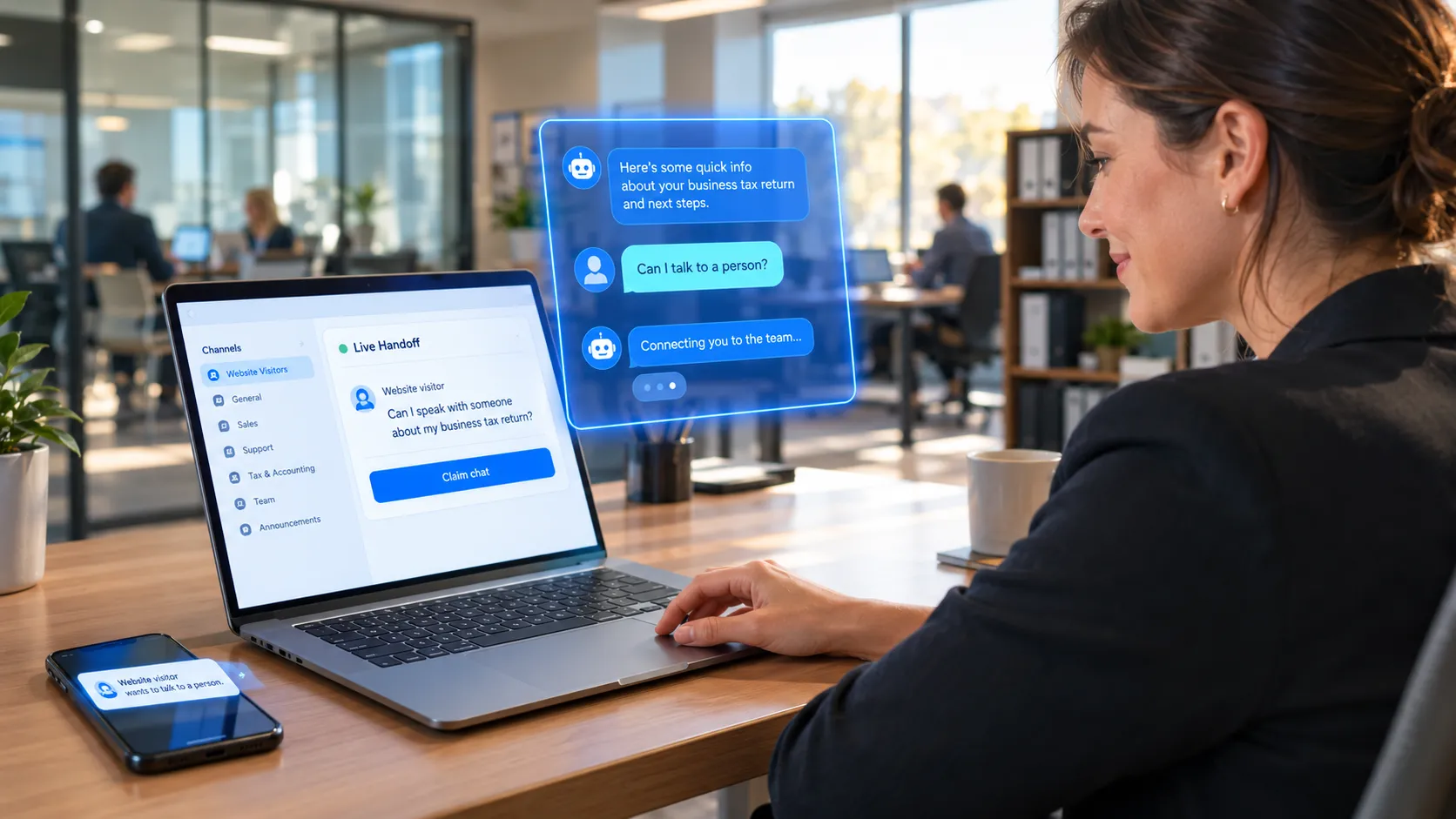 A small business owner at a desk claims a live website chat from their team messaging app, with an alert showing on their phone.